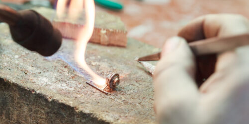 jeweler is working at his workbench, produces gold jewelry, selective focus
